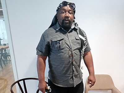 Ezekiel, LA:RISE and GRID Alternatives participant, standing in an office at the Anti-Recidivism Coalition (ARC)