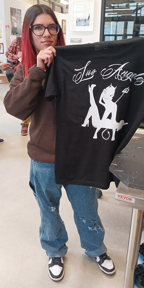 Boyle Heights YouthSource intern Gizelle Lopez showing off her Luv Angelez business logo on a freshly silk-screened t-shirt