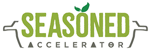 Seasoned Accelerator logo: name in green layered over a cooking pot outline with herb leaf garnish on the top