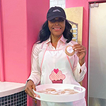 Angella, owner of Angella's Sweet Spot, with a tray of baked treats